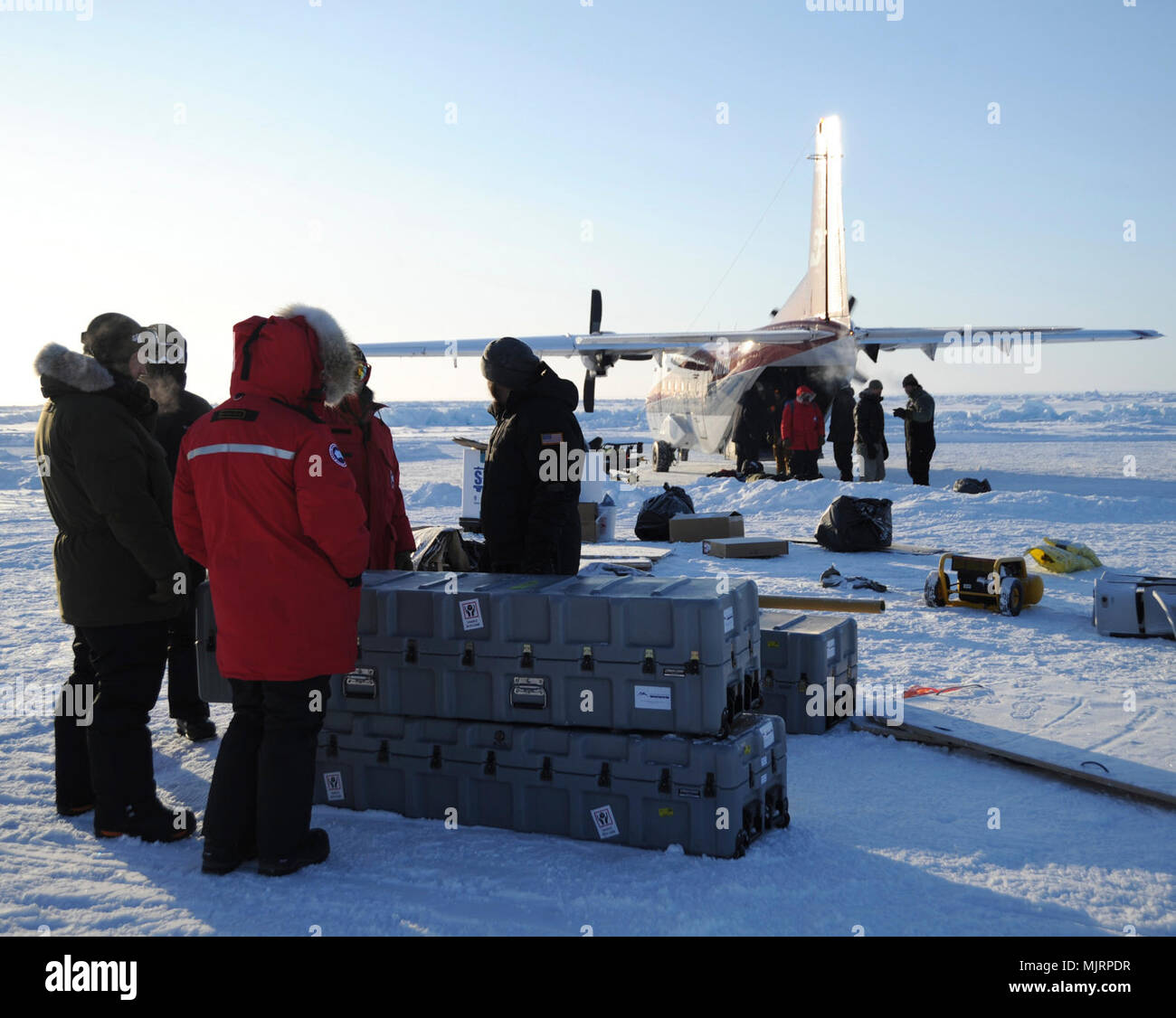 BEAUFORT SEA (March 21, 2018) Personnel at Ice Camp Skate load equipment onboard aircraft in preparation for camp breakdown during Ice Exercise (ICEX) 2018. ICEX 2018 is a five-week exercise that allows the Navy to assess its operational readiness in the Arctic, increase experience in the region, advance understanding of the Arctic environment, and continue to develop relationships with other services, allies and partner organizations. Armed Forces and civilians displaying courage bravery dedication commitment and sacrifice Stock Photo