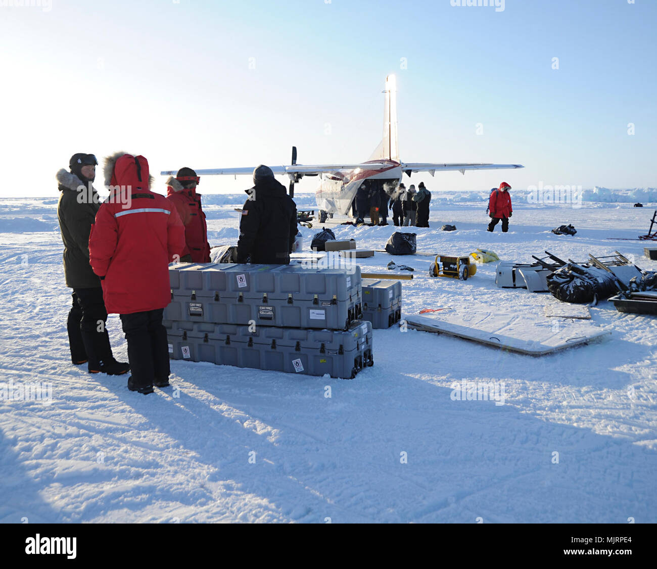 BEAUFORT SEA (March 21, 2018) Personnel at Ice Camp Skate load equipment onboard aircraft in preparation for camp breakdown during Ice Exercise (ICEX) 2018. ICEX 2018 is a five-week exercise that allows the Navy to assess its operational readiness in the Arctic, increase experience in the region, advance understanding of the Arctic environment, and continue to develop relationships with other services, allies and partner organizations. Armed Forces and civilians displaying courage bravery dedication commitment and sacrifice Stock Photo
