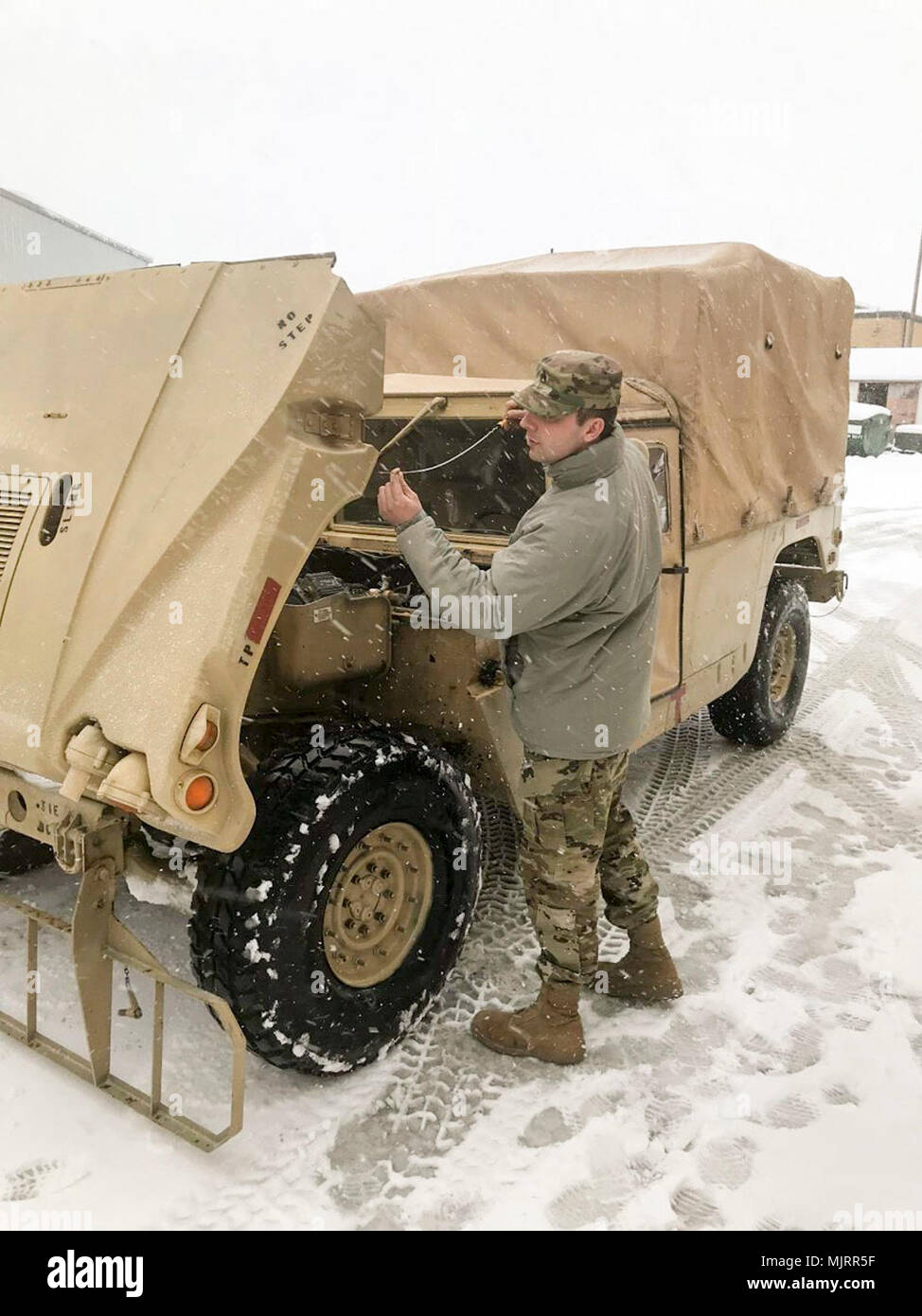 Staff Sgt. Robert Beard with the 3622nd Support Maintenance Company, 728th Combat Support Sustainment Battalion, 213th Regional Support Group, Pennsylvania Army National Guard, conducts preventive maintenance checks and services (PMCS) on his High Mobility Multipurpose Wheeled Vehicle (Humvee) in preparation for mission support during Winter Storm Toby March 21 in Spring City, Pa. Armed Forces and civilians displaying courage bravery dedication commitment and sacrifice Stock Photo