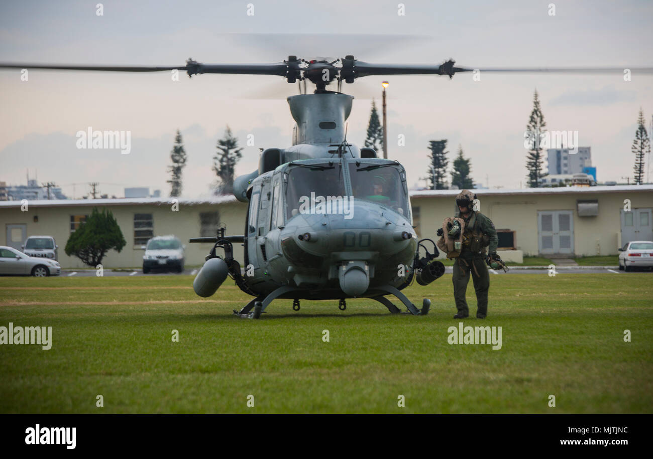 U.S. Marine Corps crew chief unloads flight gear from a UH-1Y Venom at Camp Foster, Okinawa, Japan, Dec. 15, 2017. Marine Light Attack Helicopter Squadron 369 provided Lt. Gen. Brian D. Beaudreault, deputy commandant of plans, policies and operations, a flight around the Okinawa Prefecture to assess the service quality of the Marine Corps chowhalls. The “gunfighters’” readiness to act upon a moment’s notice is crucial to maintaining a stronger, more capable forward deployed force in the Indo-Asia-Pacific region. HMLA-369, Marine Aircraft Group 39, 3rd Marine Aircraft Wing, is currently forward Stock Photo