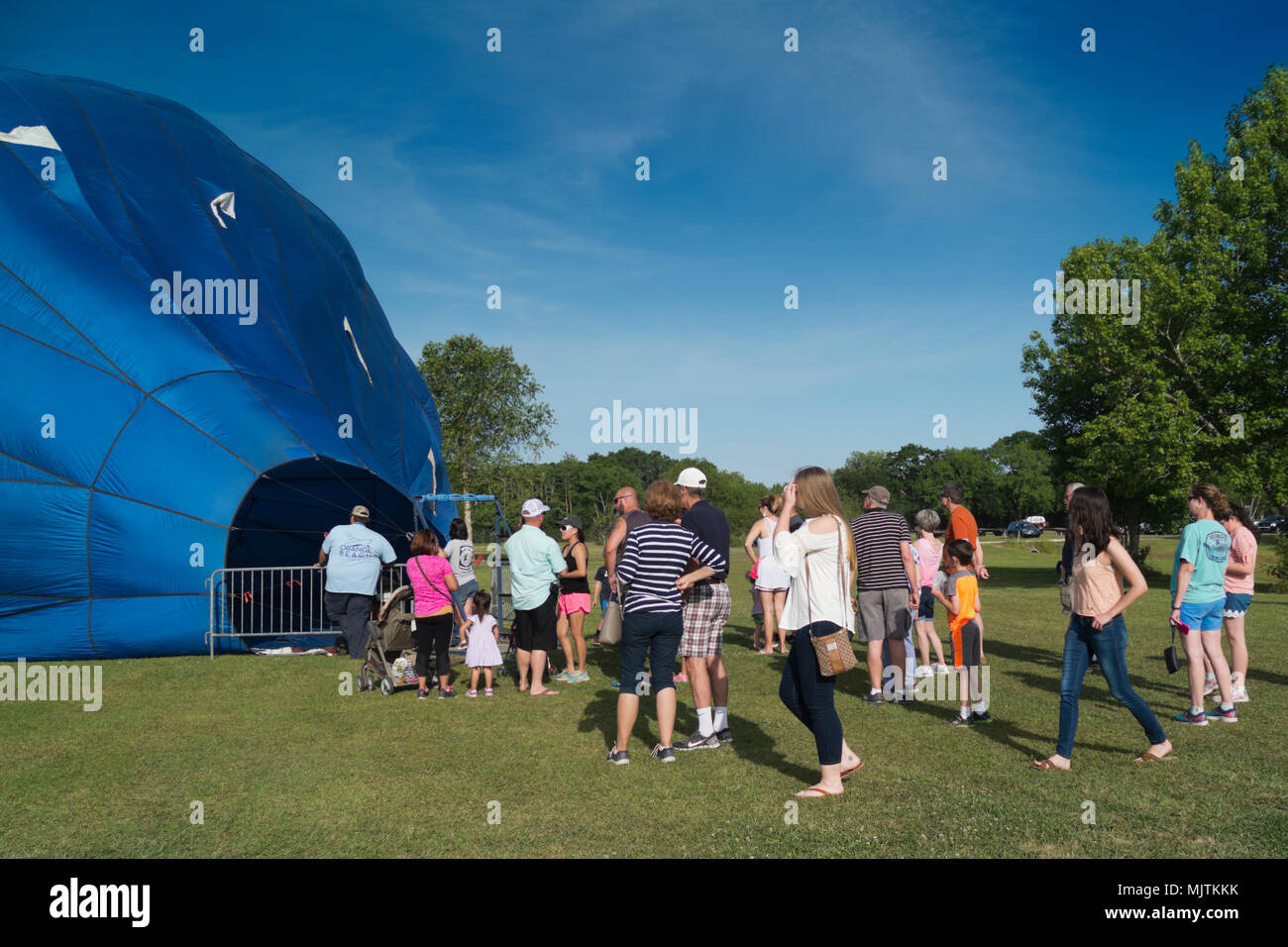 People lined up to walk inside a partially inflated hot air balloon at