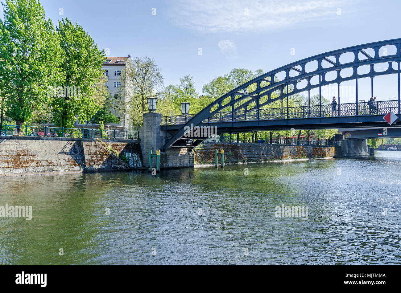 Berlin, Germany - April 22, 2018: Banks of the river Spree with its arched footbridge Gerickersteg and pedestrians on it  in the city center in spring Stock Photo