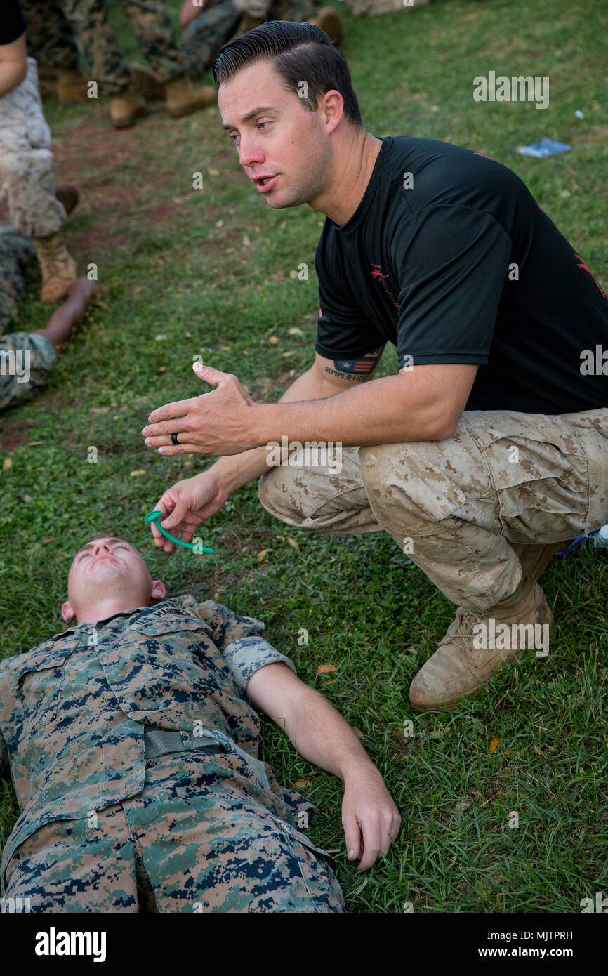 U.S. Navy Hospital Corpsman 3 Bryce Meeker, with Naval Health Clinic Hawaii, Marine Corps Base Hawaii, instructs Marines in the treatment of a casualty during a professional military educartion (PME) event, Dec. 8, 2017. The PME focused on crew-served weapons, radio operating procedures, and medical care techniques to sustain military skills and produce readiness. (U.S. Marine Corps Photo by Sgt. Alex Kouns) Stock Photo