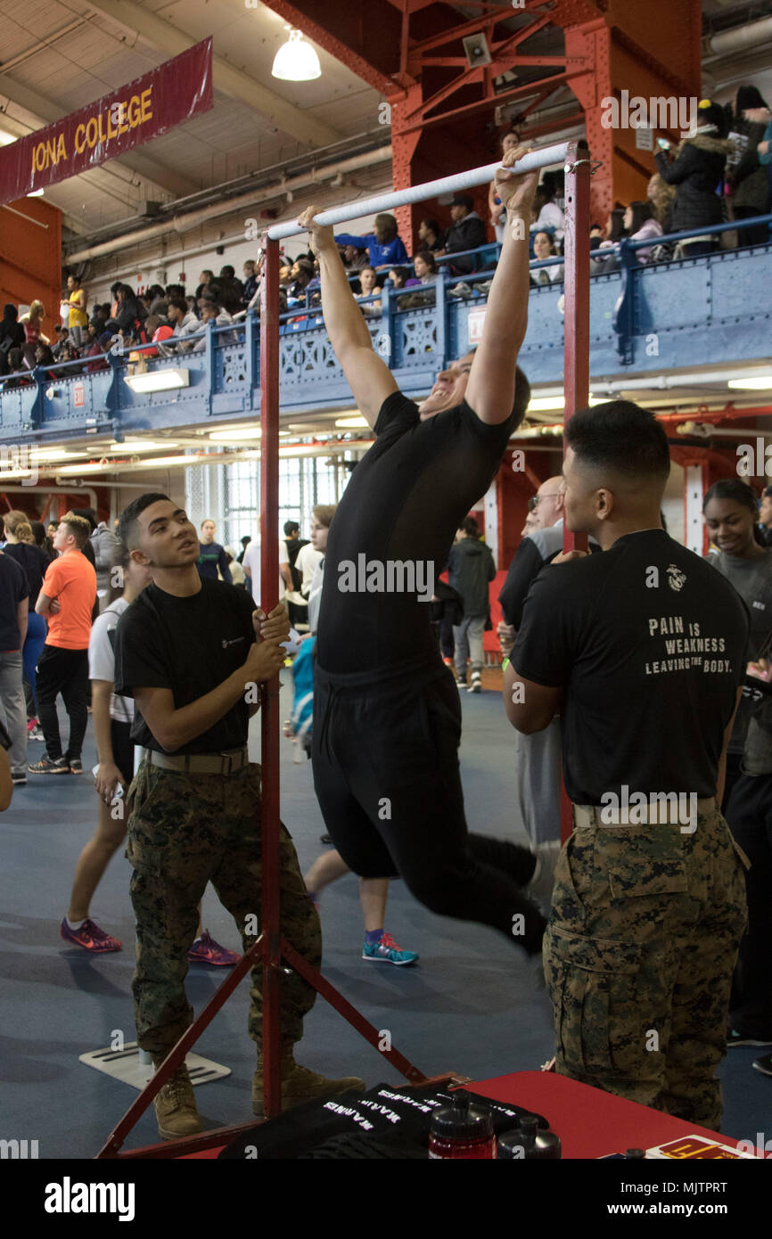 U.S. Marines cheer on a high school student during the pull up bar