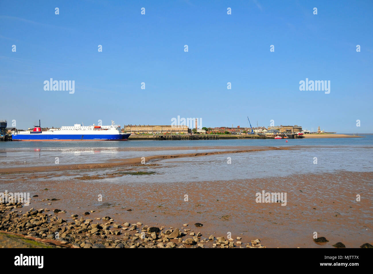 Blue sky view, from Knott End, across low water River Wyre to Stena Leader Ferry, Pharos Lighthouse snd Beach Lighthouse at Fleetwood, Lancashire, UK Stock Photo