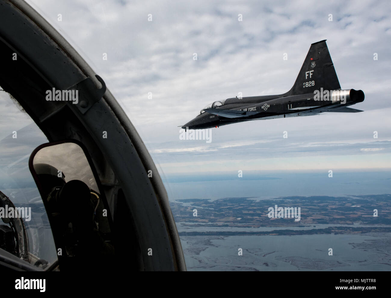 A T-38 Talon from the 71st Fighter Training Squadron flies in formation with another T-38 over Eastern Shore, Va. after participating in a RED AIR mission, Dec. 7, 2017. The 71st FTS, also referred to as the “Ironmen”, is one of three flying squadrons assigned to the 1st Fighter Wing at Joint Base Langley-Eustis, Va..(U.S. Air Force Photo by Staff Sgt. Carlin Leslie) Stock Photo