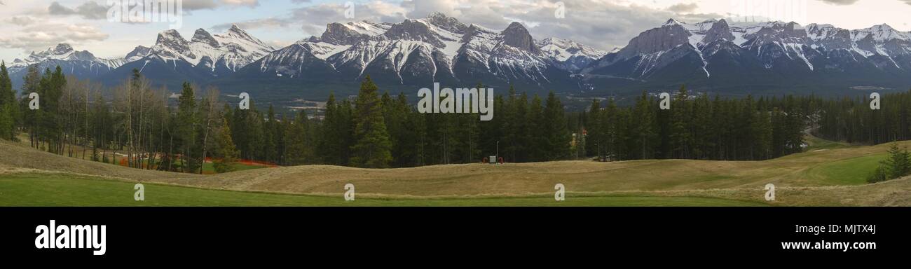 Wide Panoramic Springtime Landscape of Snowcapped Mountains above Bow Valley in Canmore Alberta near Banff National Park in Canadian Rockies Stock Photo