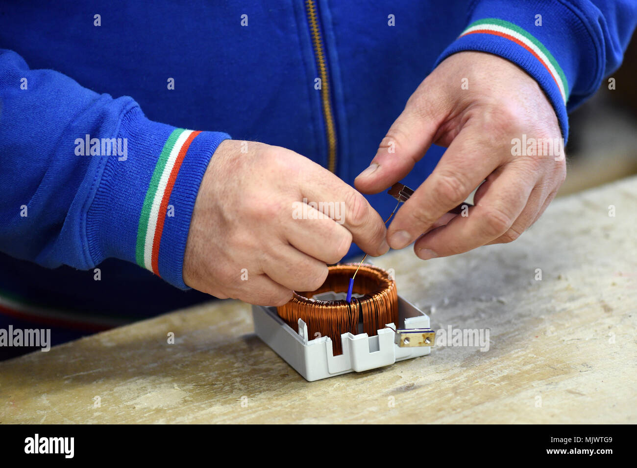 Close up view of man working at assembling line with electric components Stock Photo