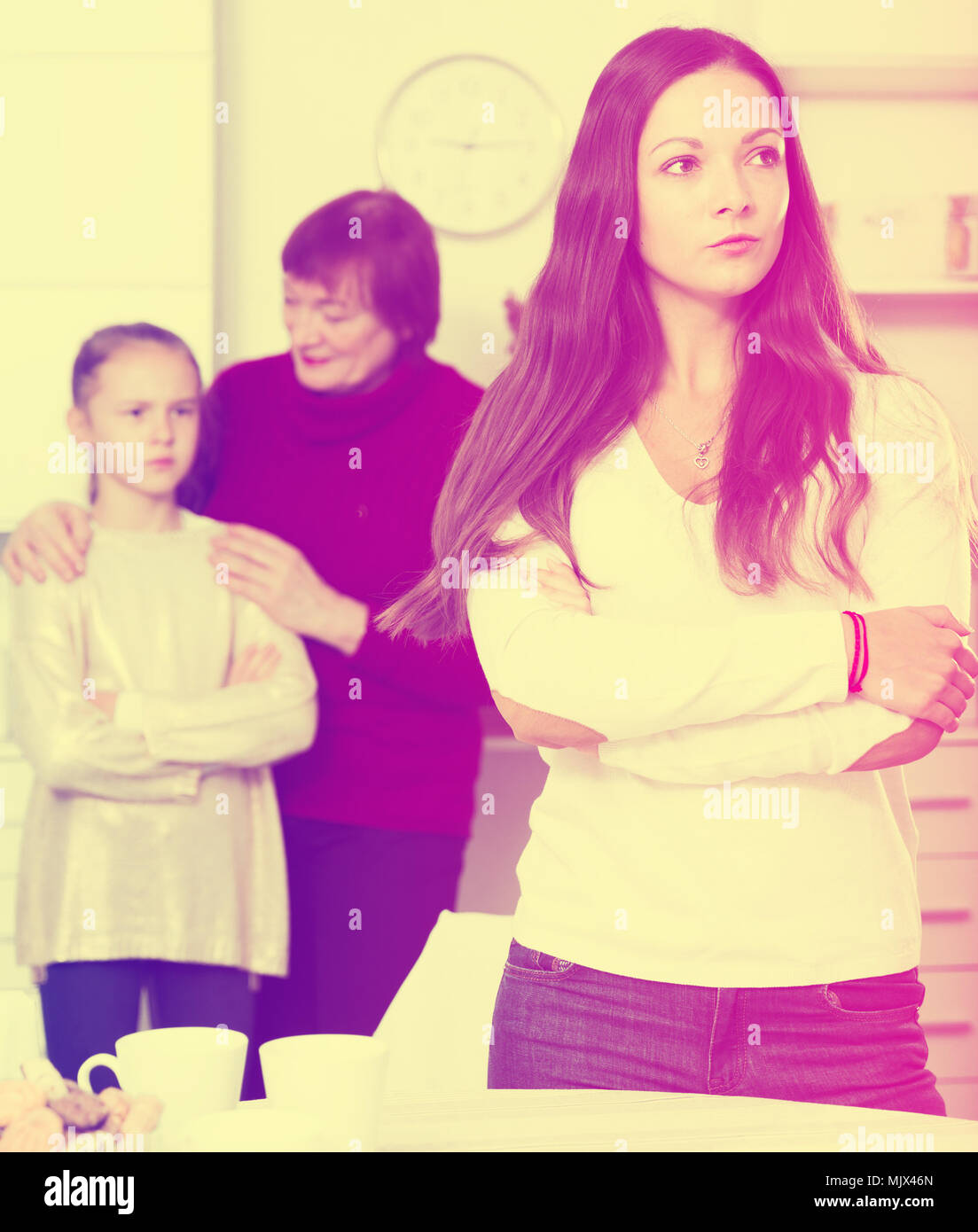 Chagrined young woman having conflict with little daughter and mother ...