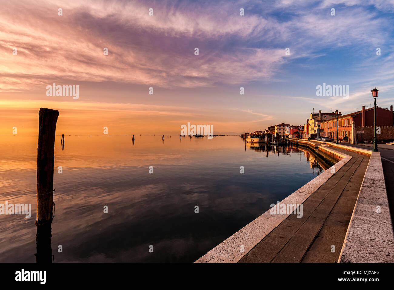 Romantic sunset on the Venice lagoon. Island of Pellestrina and town. Stock Photo