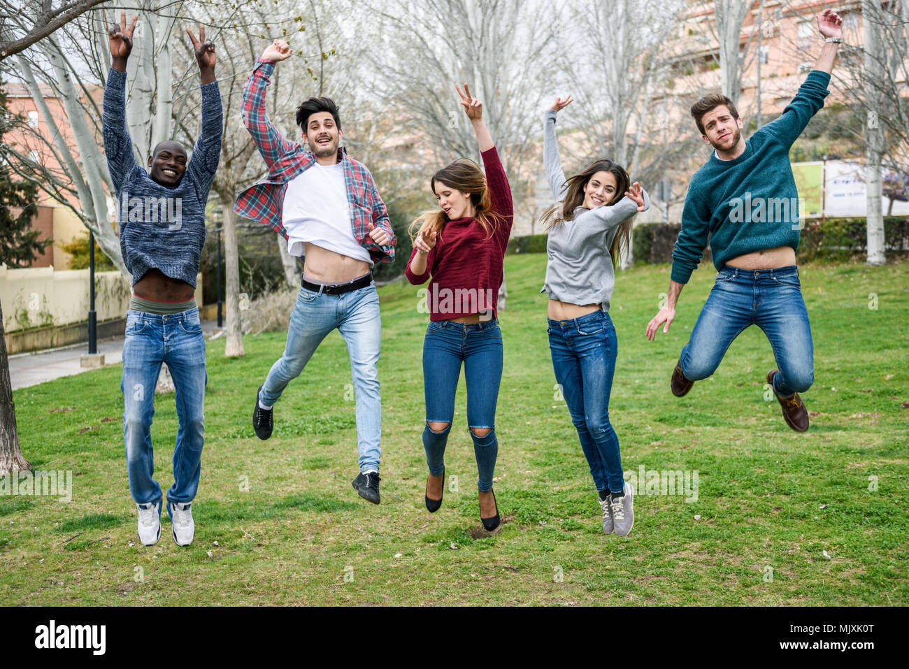 Group of multi-ethnic young people jumping together outdoors Stock ...