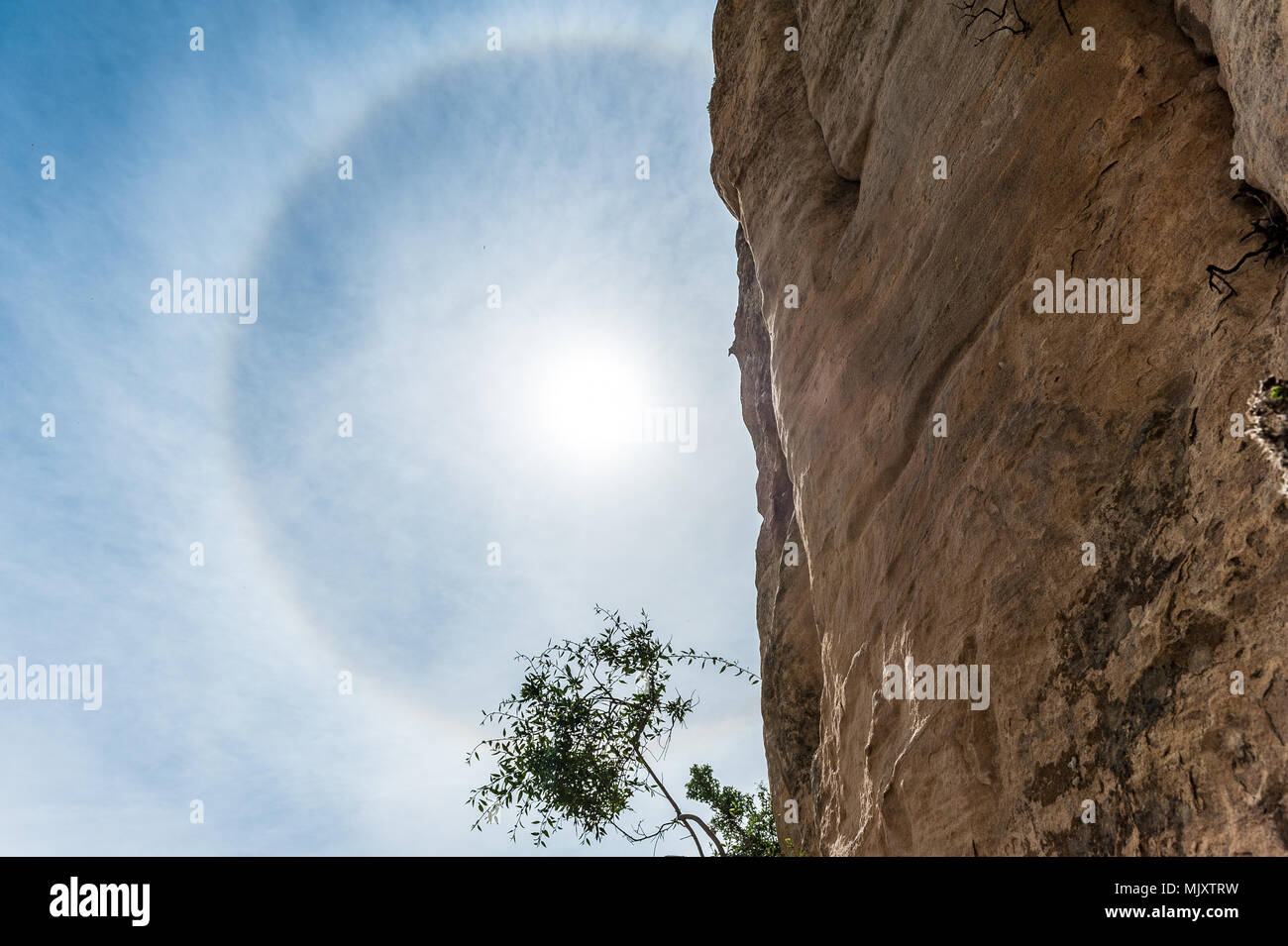 Halo is the name for a family of optical phenomena produced by light interacting with ice crystals suspended in the atmosphere Stock Photo
