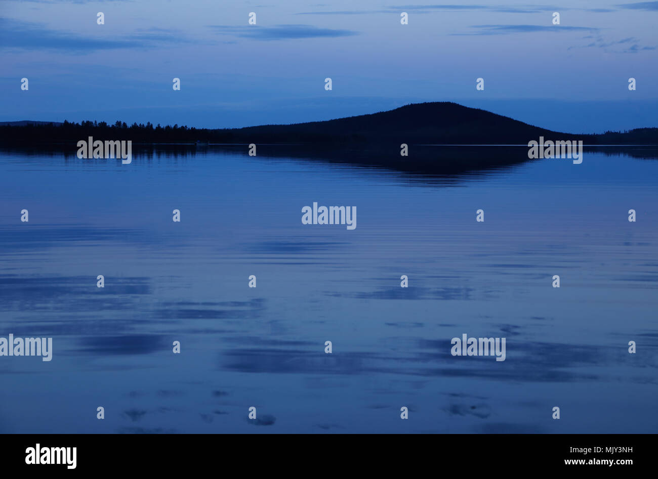 Stillness of twilight in northern Sweden with river in the foreground. Stock Photo