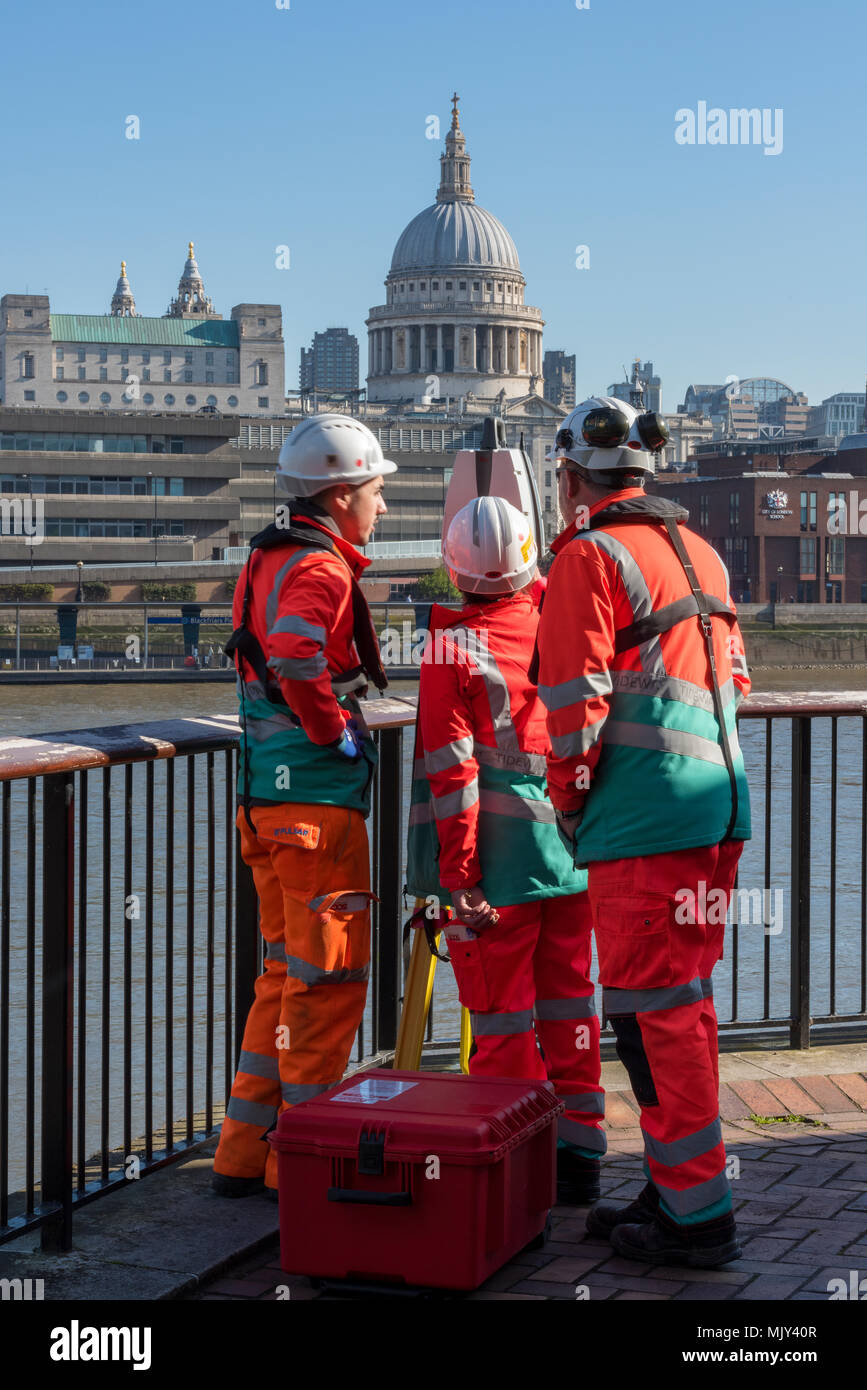 civil engineers or construction workers and surveyors taking readings