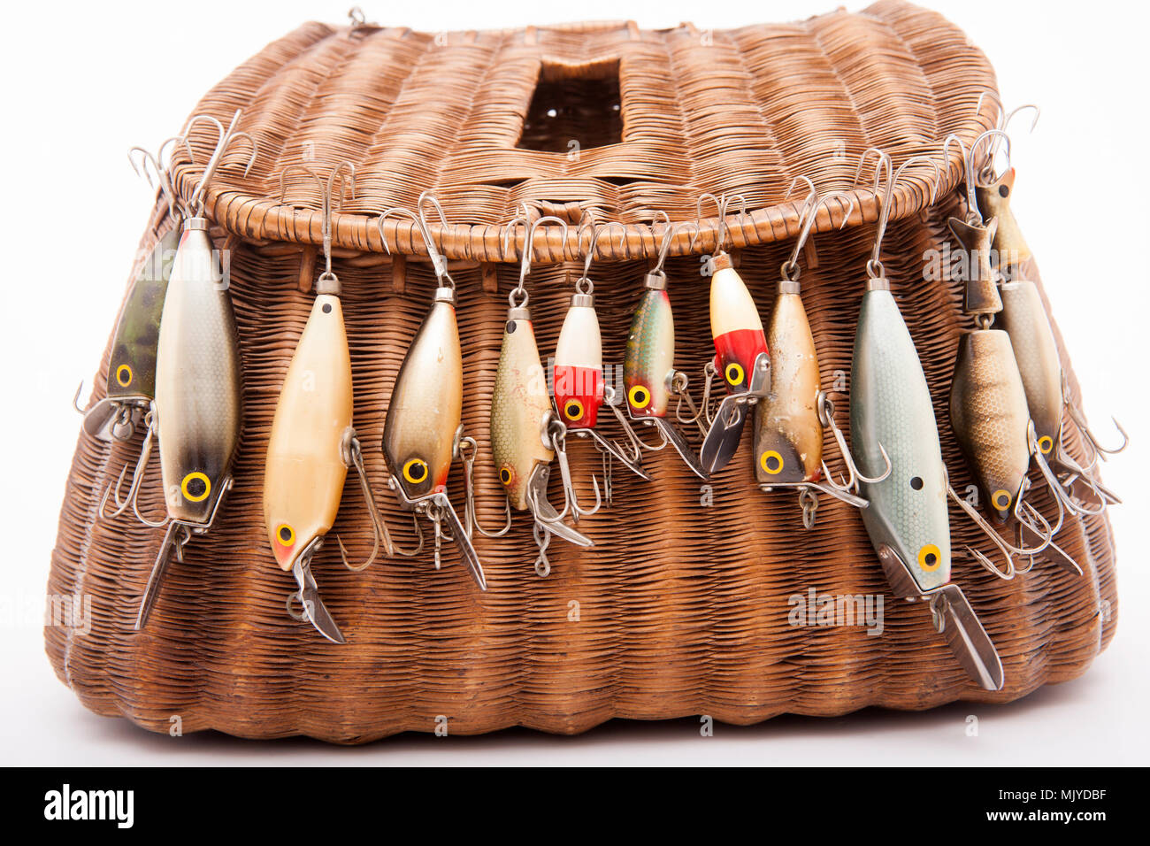 A selection of vintage fishing lures, also known as plugs, possibly made by Woods MFG. They are shown displayed on a woven fishing creel. Dorset Engla Stock Photo