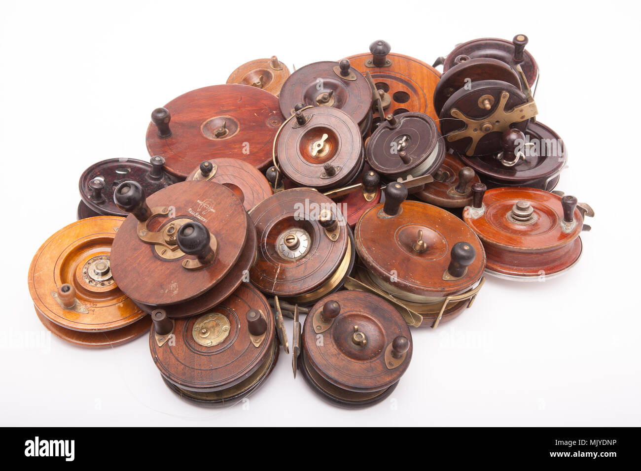 A collection of mostly wooden centrepin fishing reels from a large