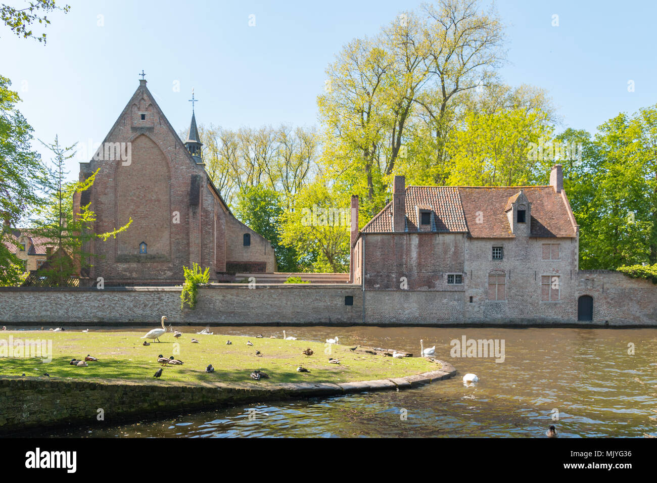 Bruges, Belgium - Mai 4, 2018: View on the Dijver river with the medieval beguinage on the background Stock Photo