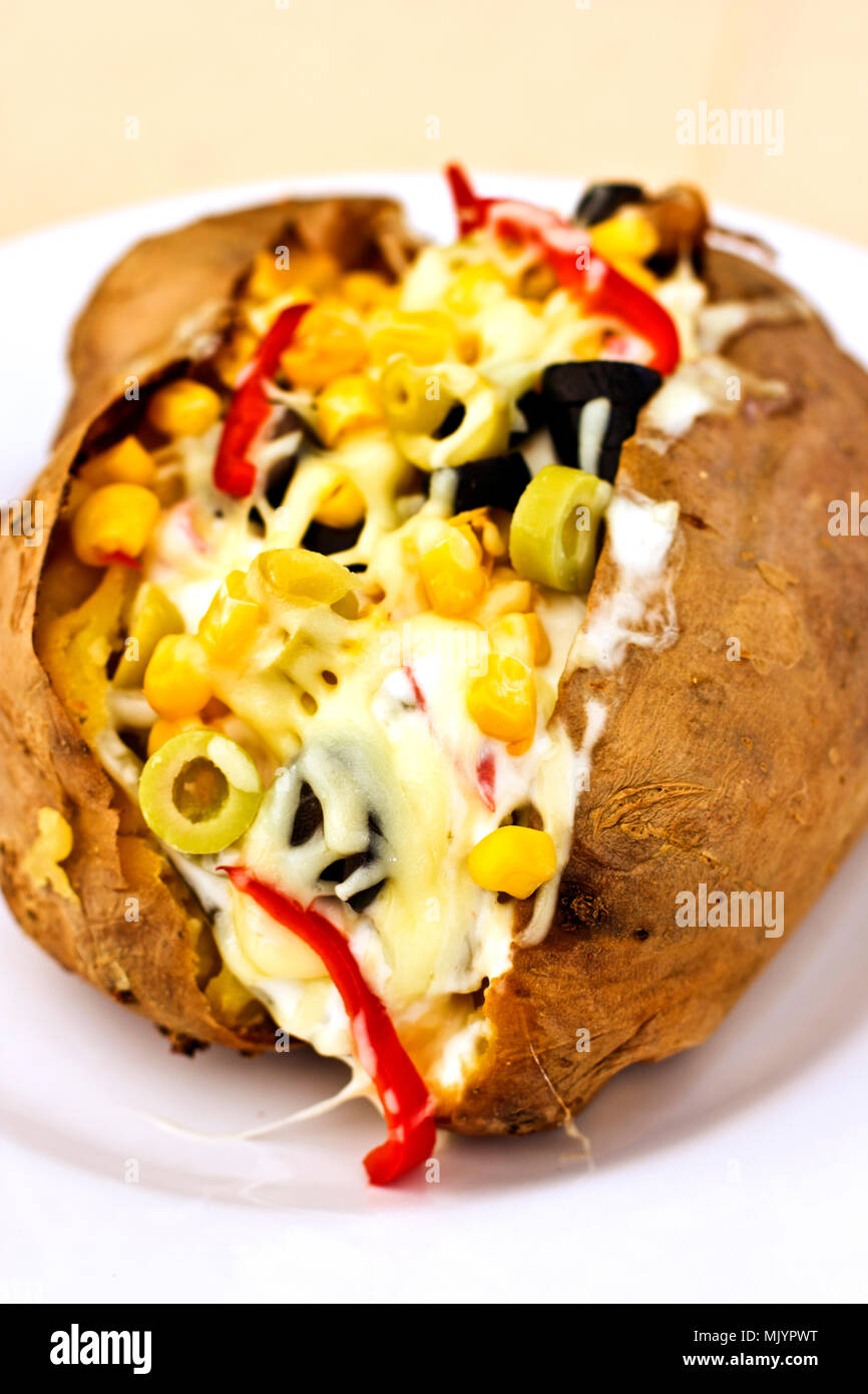 Baked kumpir potato stuffed with the cheese, sausage, olives, peppers and corn Stock Photo Alamy