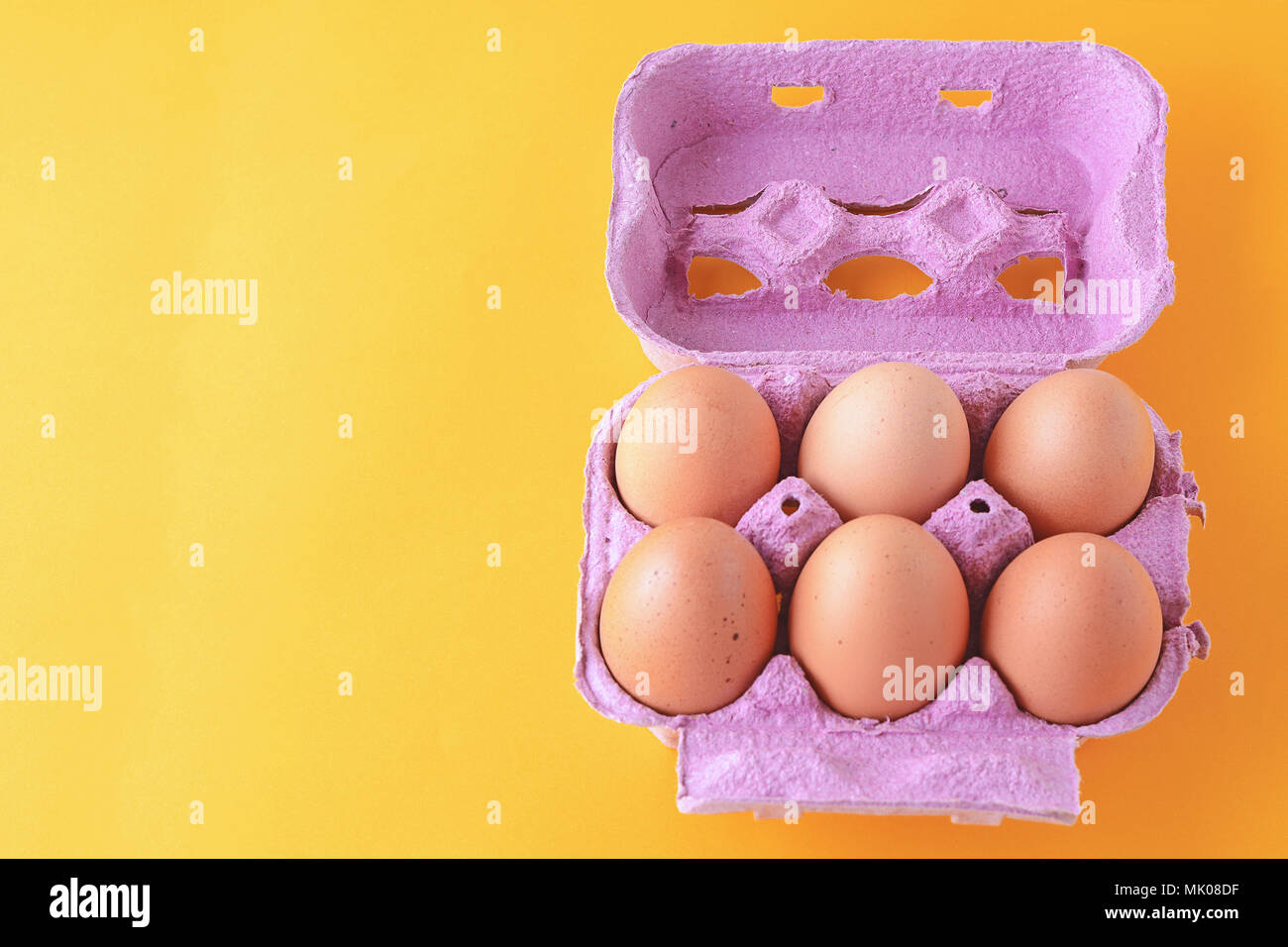 Top view of six brown eggs on box. Fresh food concept. Yellow background Stock Photo