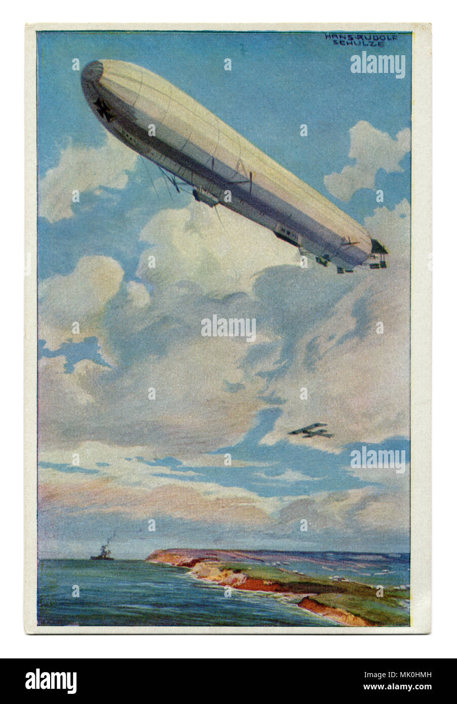Old German postcard: A huge Zeppelin airship flies over the coast of the sea against the background of a warship and aircraft, first world war 1914-18 Stock Photo