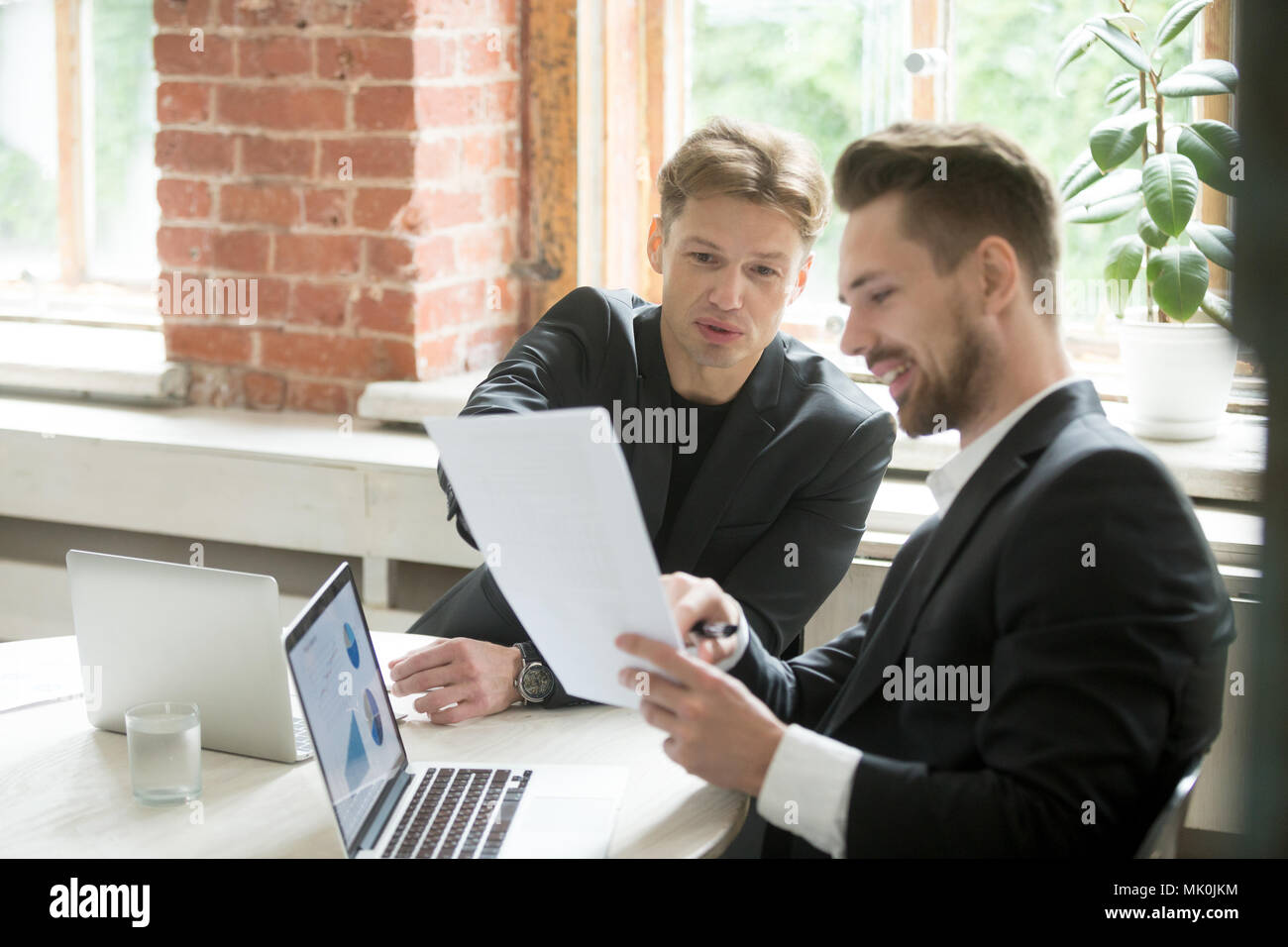 Manager explaining financial project details to colleague Stock Photo