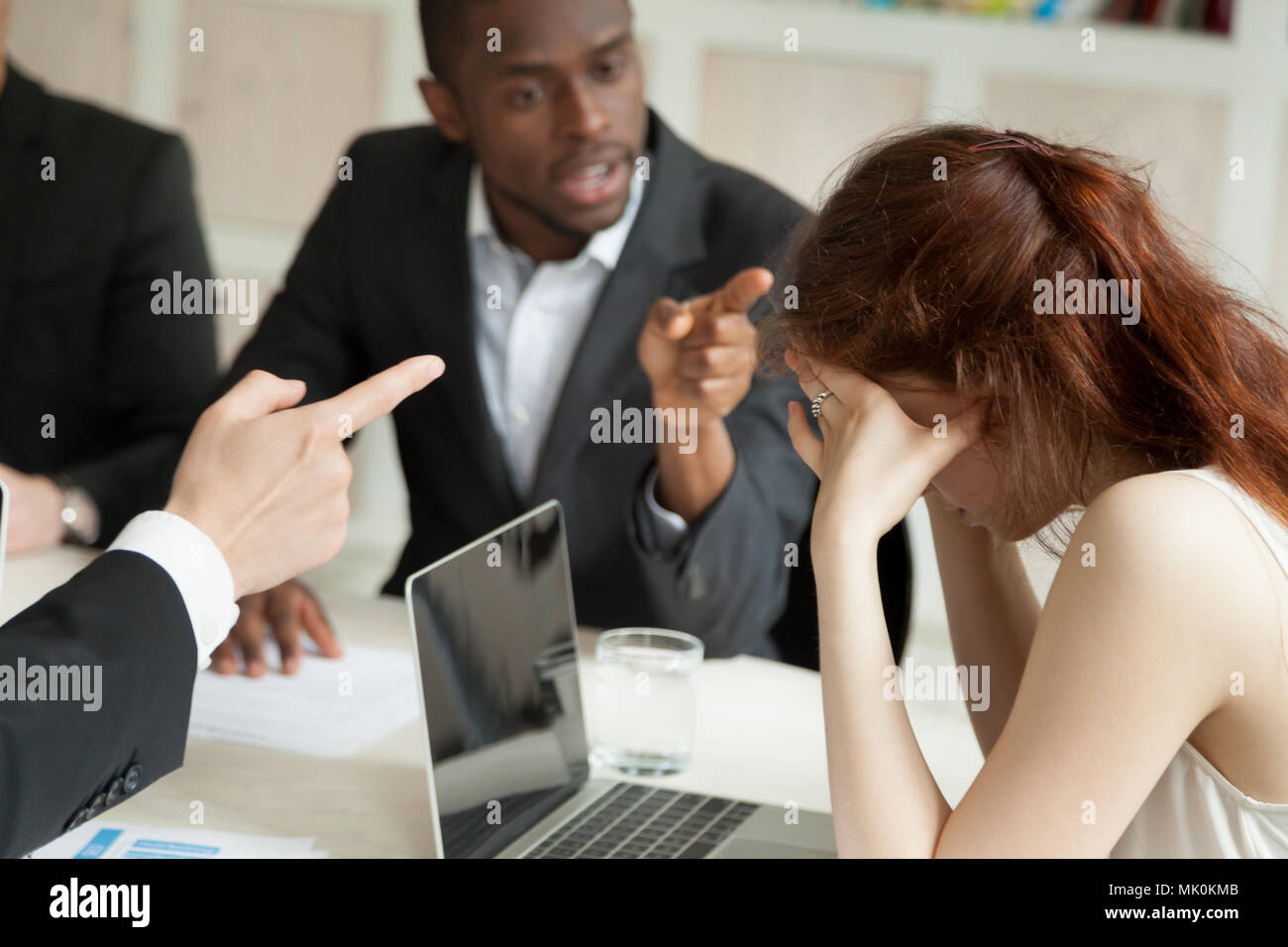 Female worker bullied by male colleagues Stock Photo