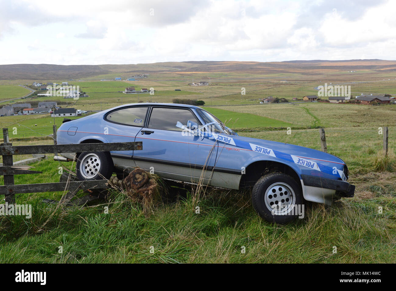 Classic Ford Capri involved in a an accident were it has gone of the road and into a fence Stock Photo