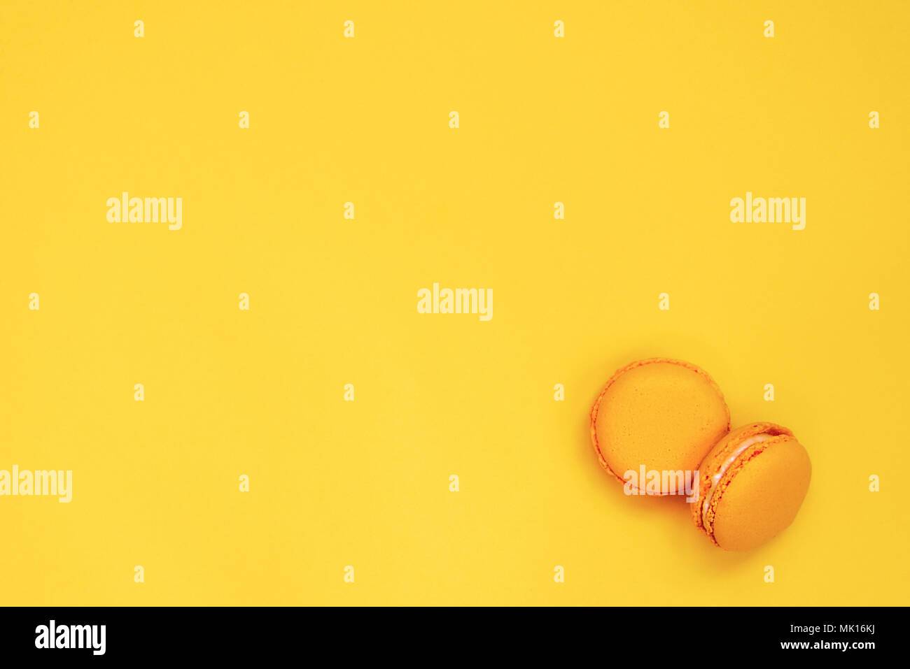 Top view of yellow macaroons over yellow background. Copy space. Stock Photo