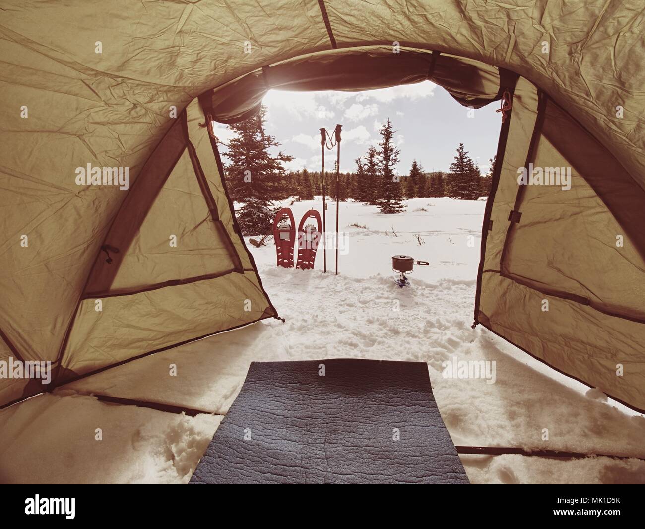 Camping in winter forest, cooking in front of tent in snow. Making a