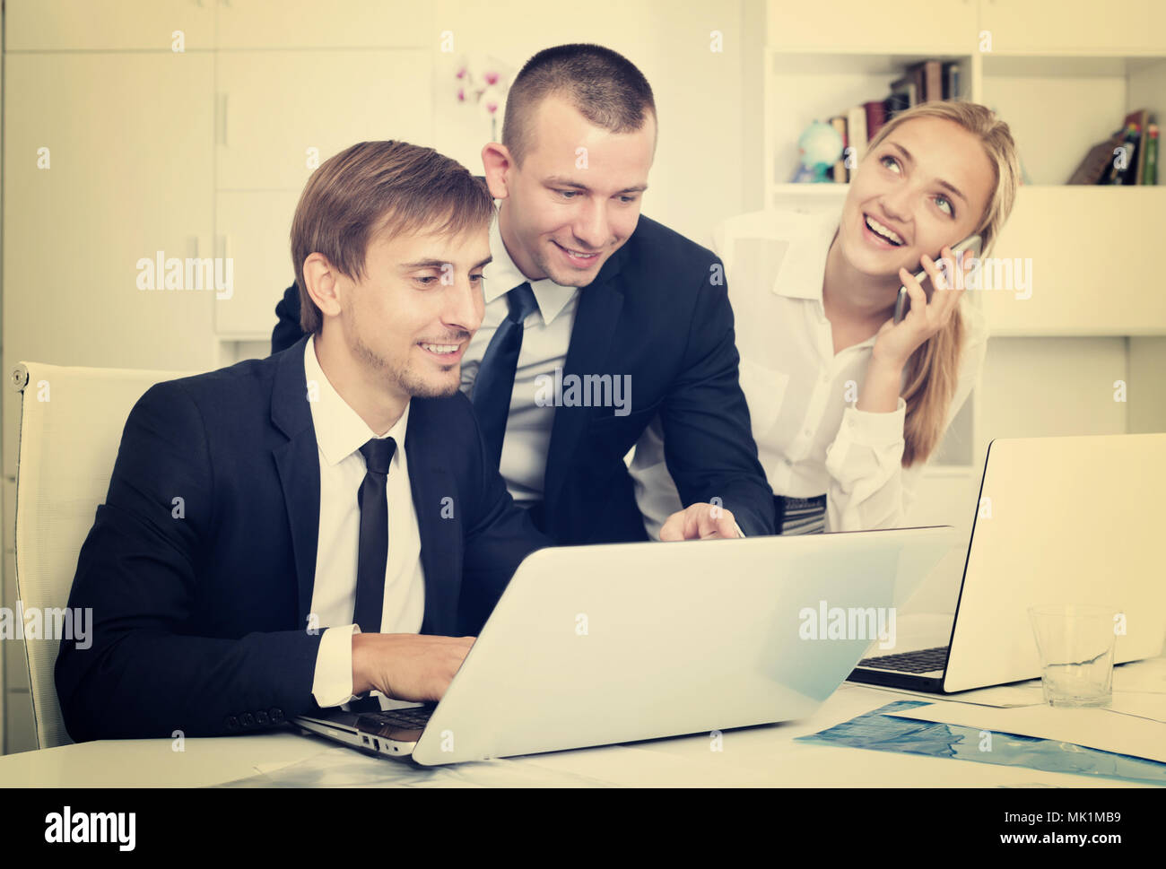 Three beautiful business colleagues working and discussing working task ...