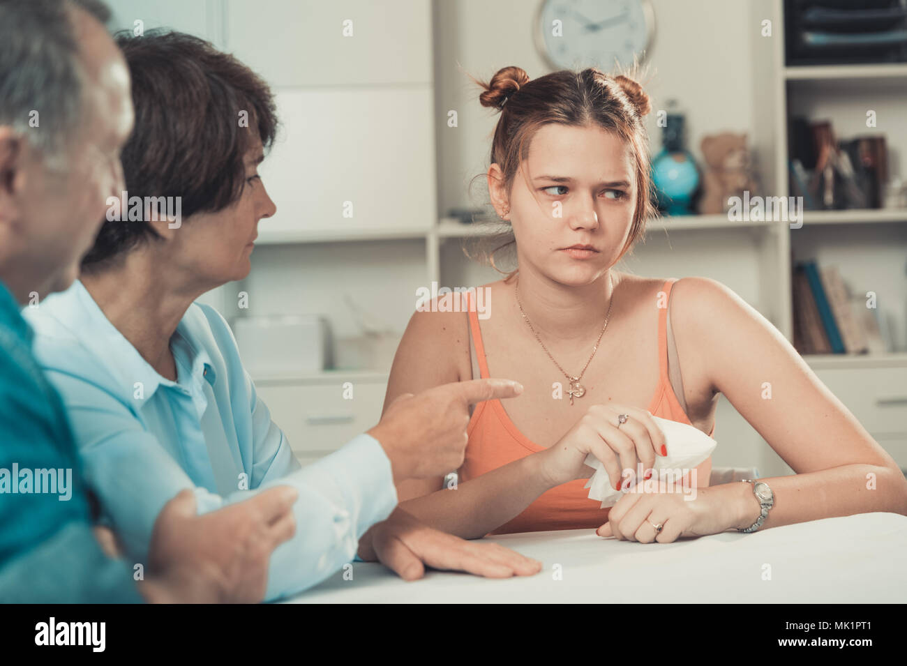Mom and dad are supporting a sad daughter at the table at home Stock ...