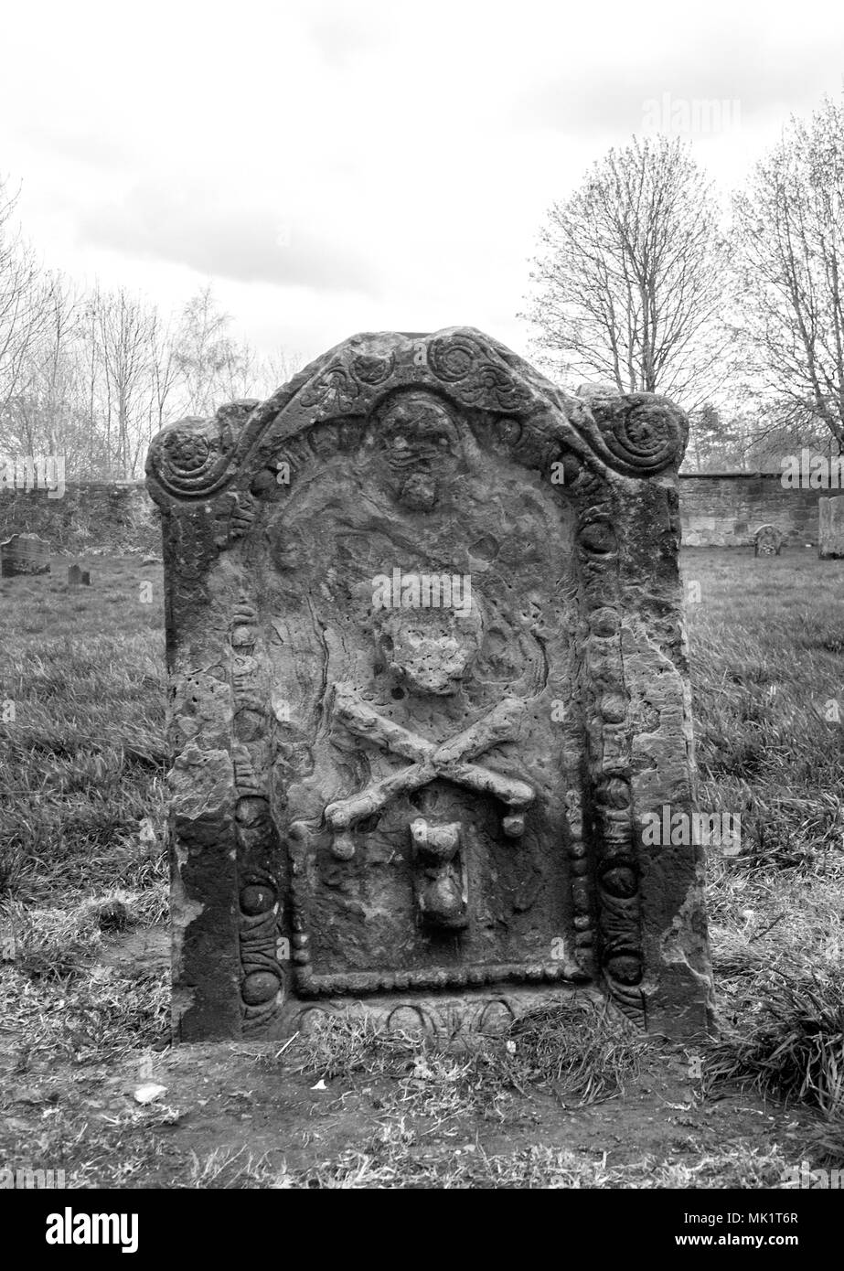 GLASGOW, SCOTLAND - APRIL 23rd 2018: A black and white photograph of a skull and bone cross on a gravestone at the Govan Old Parish Church. Stock Photo