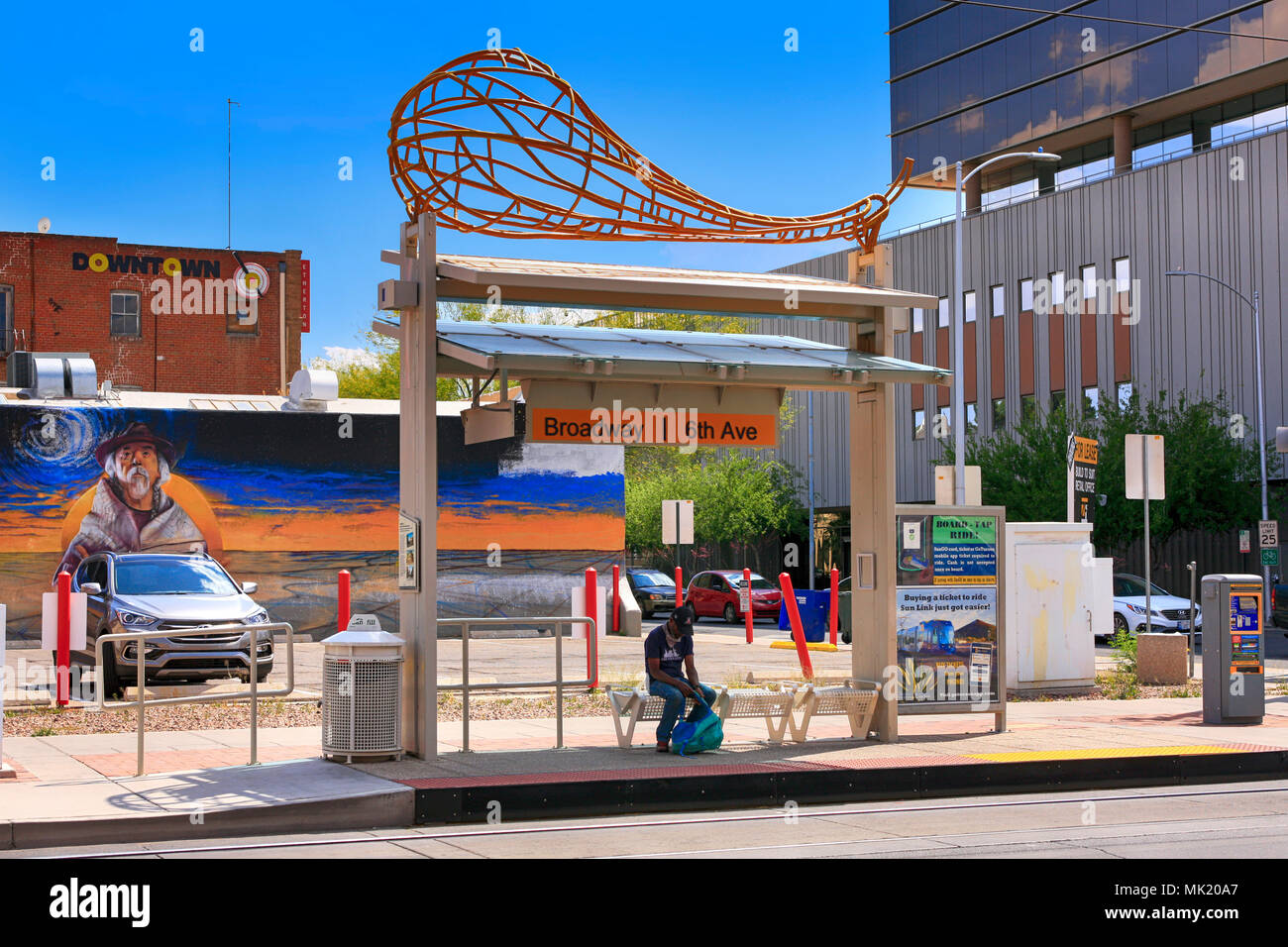 Man waits at a streetcar stop at Broadway and 6th in downtown Tucson AZ Stock Photo