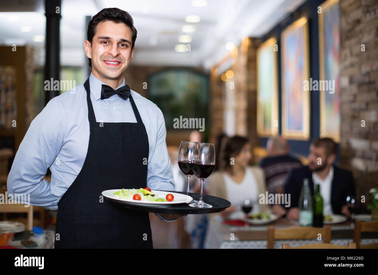 Professional friendly waiter holding serving tray for restaurant guests Stock Photo Alamy