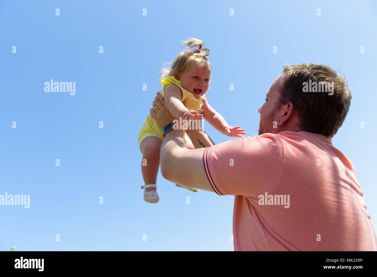Happy joyful father having fun throws up in the air child .In motion