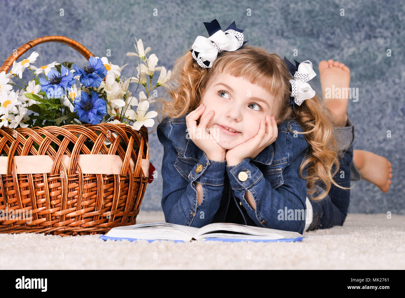 little girl reading book while lying on floor Stock Photo - Alamy