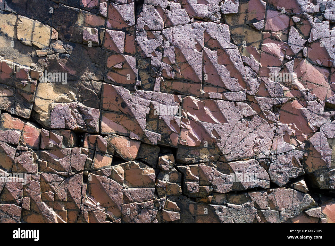 Closeup of geometric fractured rock surface of vertical volcanic dyke (see image MK28B2) on Boreraig Beach, Isle of Skye, Scotland, UK Stock Photo