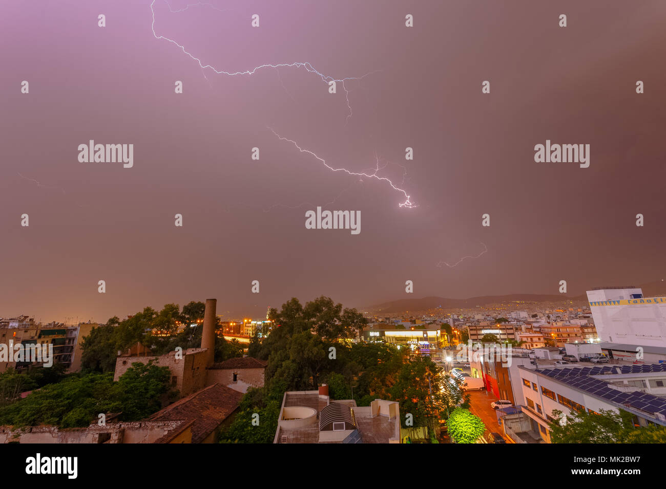 Intense stormy weather night with lightning bolts and thunderbolts against a dark cloudy sky.  Sudden seasonal weather changes often find city service Stock Photo