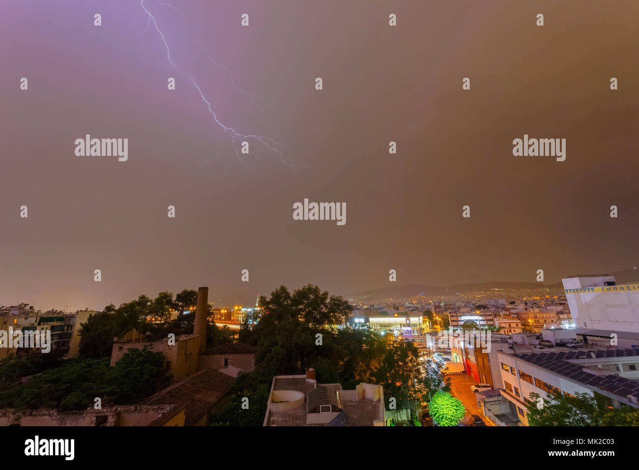 Intense stormy weather night with lightning bolts and thunderbolts against a dark cloudy sky.  Sudden seasonal weather changes often find city service Stock Photo