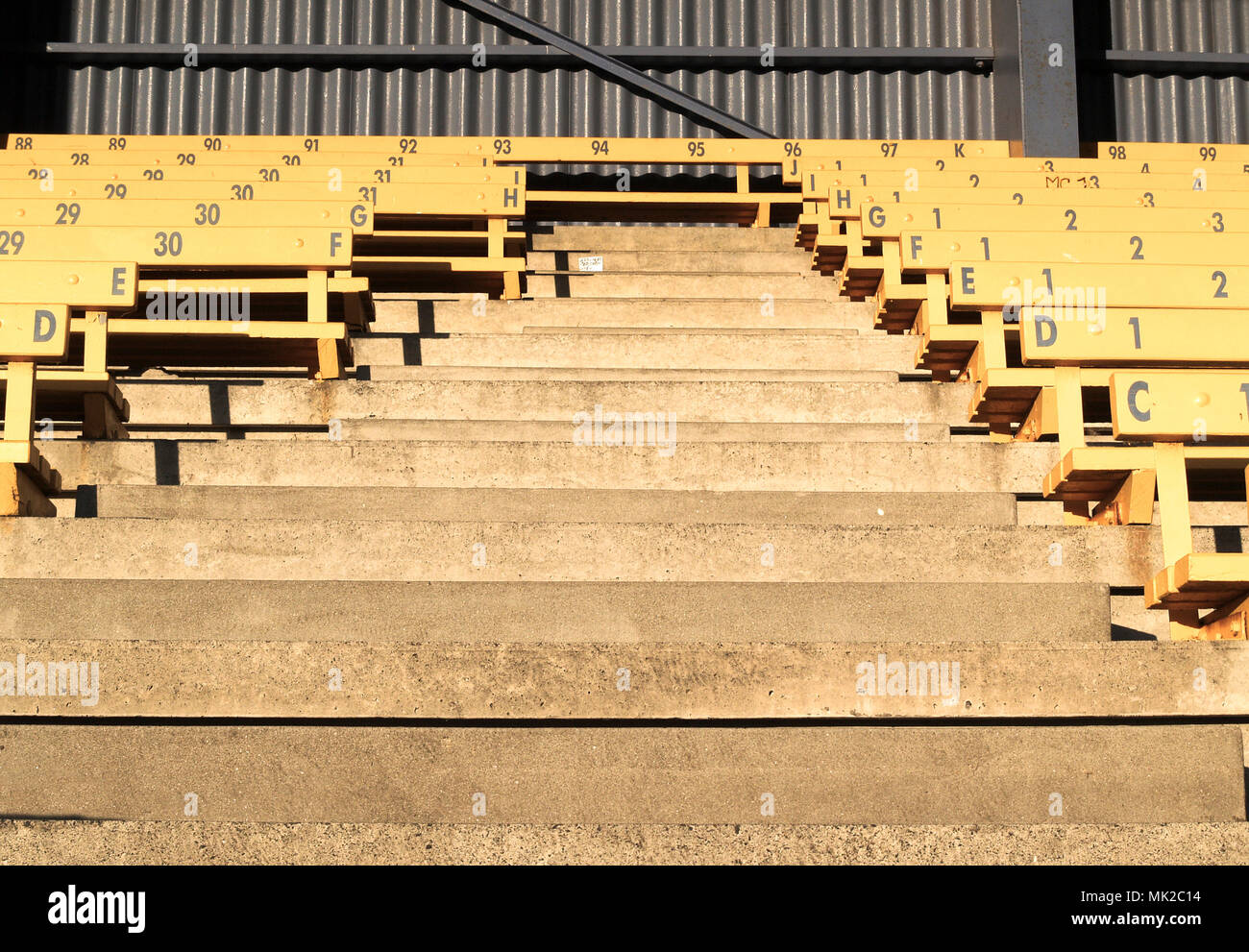 Rows of numbered oldfashioned grandstand seating divided by aisle with
