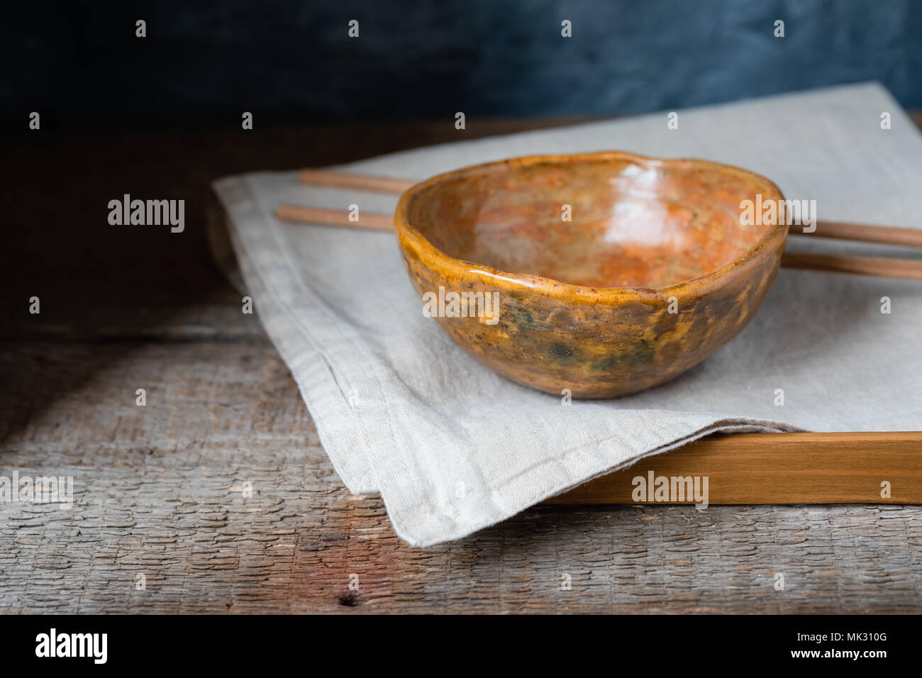 Handmade ceramic bowl on a wooden background, wabi sabi style, toned Stock Photo