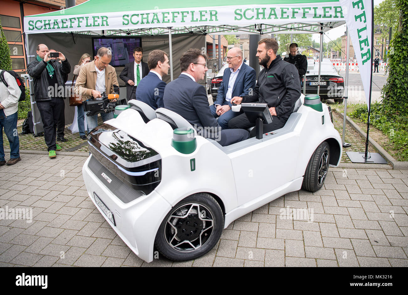 03 May 2018, Germany, Karlsruhe: Uwe Wagner (L-R), head F&E Automotive and Industry at Schaeffler, Alexander Pischon, CEO of the Karslruhe transport federation, Winfried Hermann (Alliance 90/The Greens), Baden-Wuerttemberg's Minister of Transport, and Christian Turan, engineer at Schaeffler, sit in the autonomous vehicle Schaeffler Move during the opening of the 'Testfelds Autonomes Fahren' (lit. test field autonomous driving). Photo: Sebastian Gollnow/dpa Stock Photo
