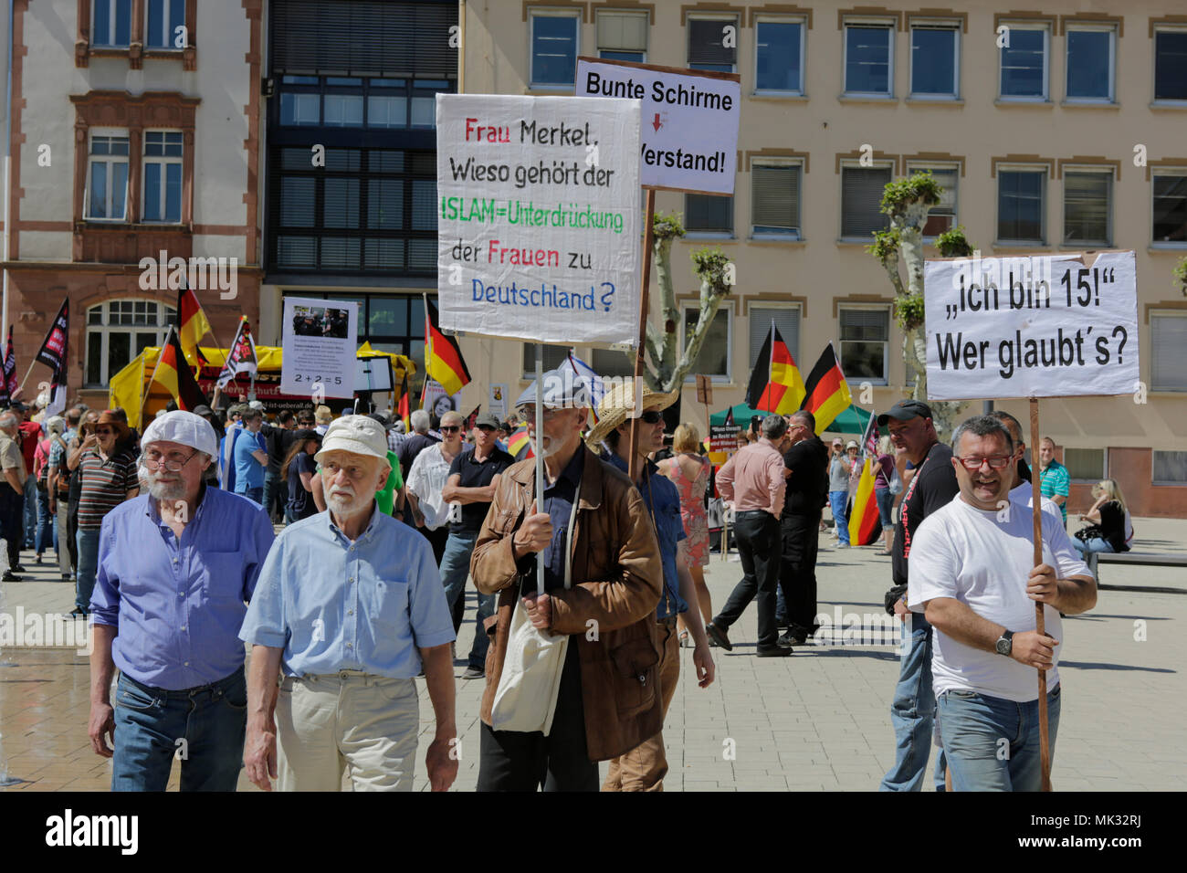Germersheim, Germany. 6th May 2018. Right-wing protesters carry placards and shout slogans at the counter protesters. Around 100 from different right-wing organisations protested in the city of Germersheim against Angela Merkel and for the security of women and children, which they see at risk by refugees and foreigners. They also called for the introduction of mandatory age checks (DNA test) by underage refugees. Credit: Michael Debets/Alamy Live News Stock Photo