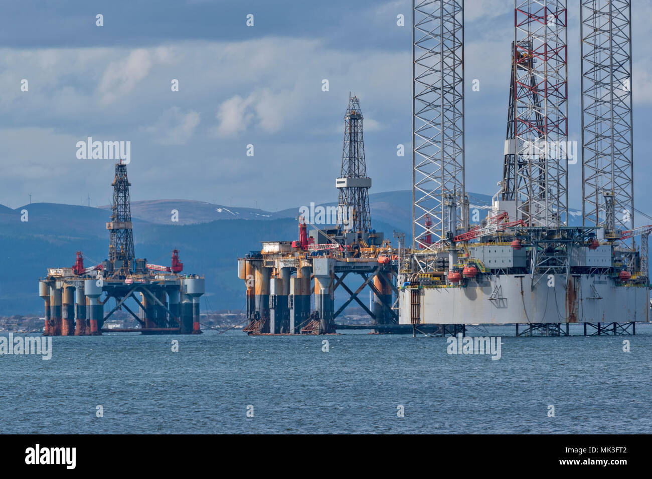 CROMARTY FIRTH SCOTLAND BAUG OIL DRILLING PLATFORM  WITH  TWO DECOMMISSIONED OR REPAIRED OIL RIGS LYING OFF CROMARTY VILLAGE Stock Photo