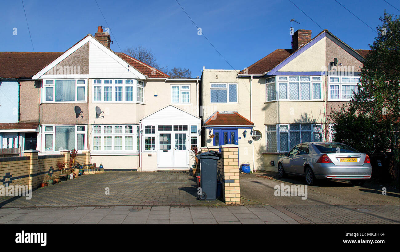London, UK: February 24, 2018: Residential properties in a London suburb with off road parking and extensions. Front view with blue sky background. Stock Photo
