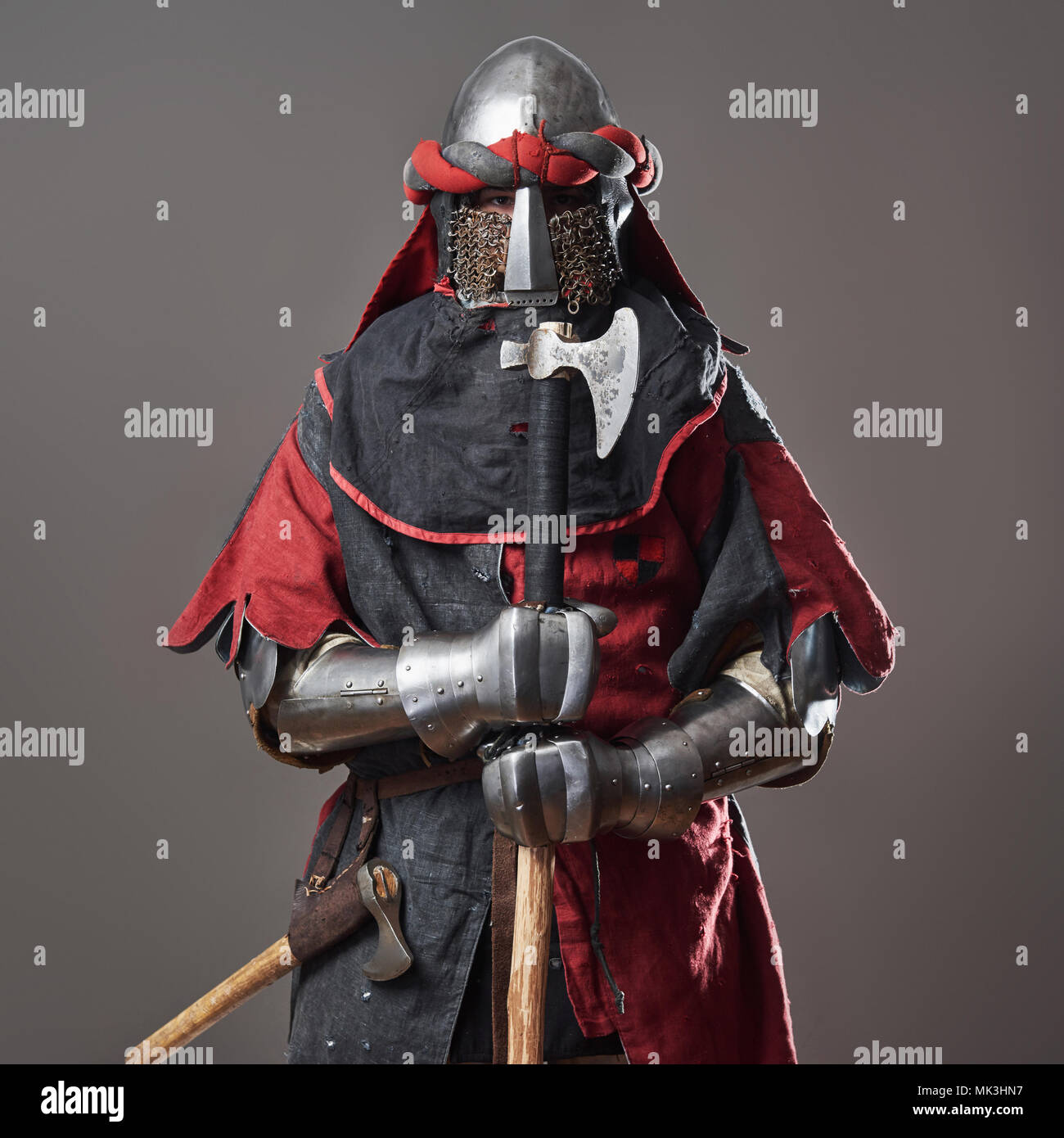 knight grey background. Portrait of brutal dirty face warrior with mail armour red and black clothes and battle axe Photo - Alamy