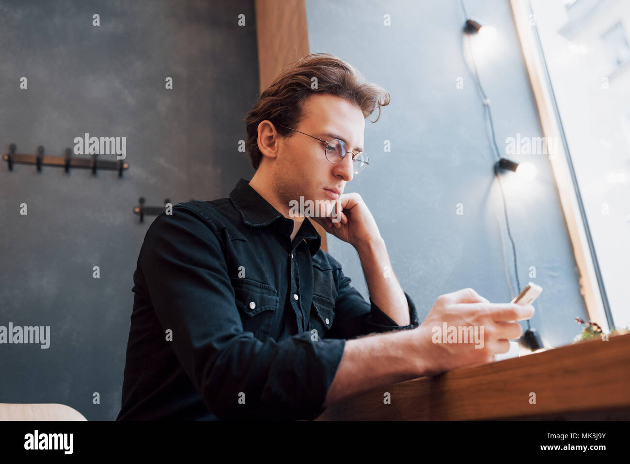 soft focus.man holding and using sell phone.while sitting and relax on sofa at modern house.concept for young people working mobile device Stock Photo