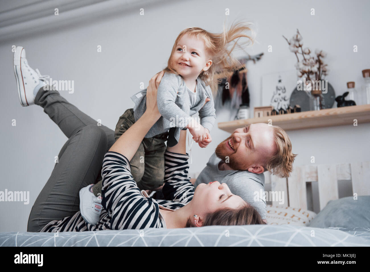 happy family mother, father and child daughter laughs in bed Stock Photo