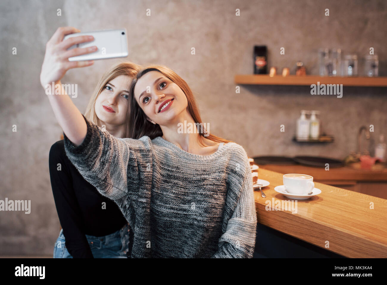 Two women friends sitting in cafe and make selfie Stock Photo