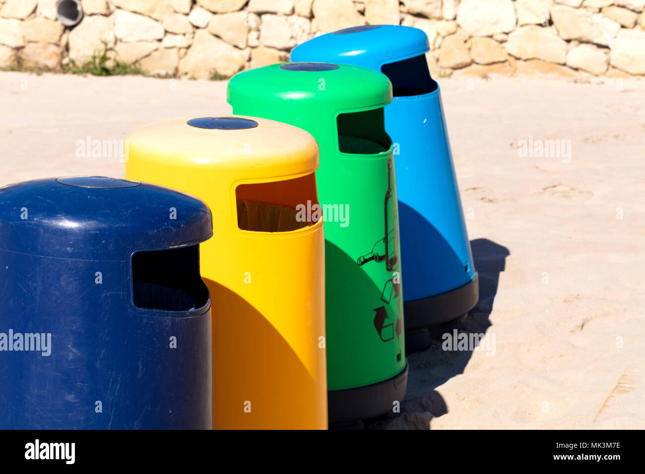 selective recicle bins with different colors in a mediterranean beach Stock Photo